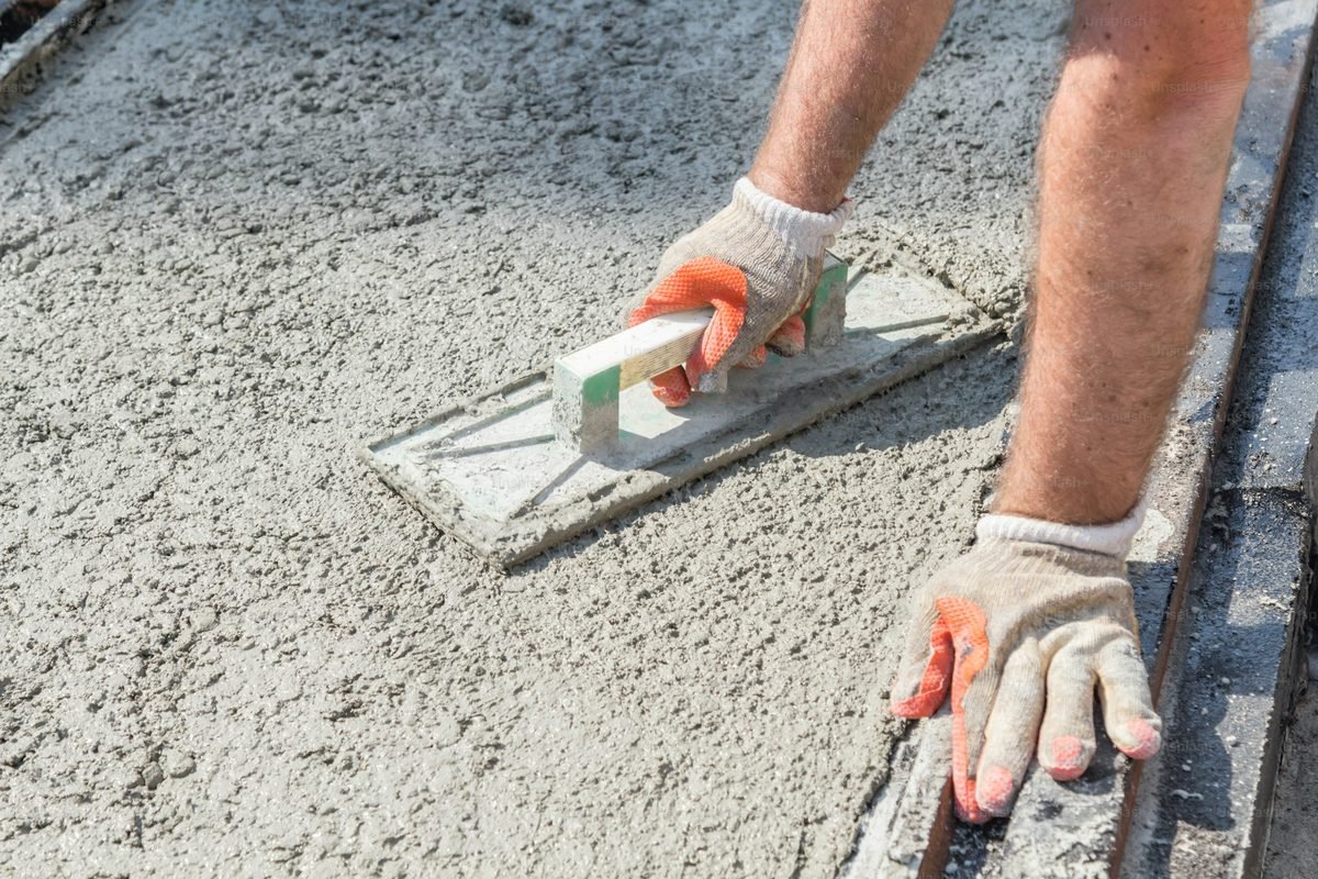 Concreter finishing a slab edge with a hand trowel